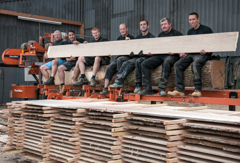 Wood-Mizer Customers Holding a Board
